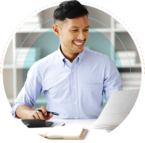 An outsourced accounting professional working on a laptop and using a calculator