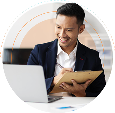 An outsourced data management professional taking notes and working on a computer
