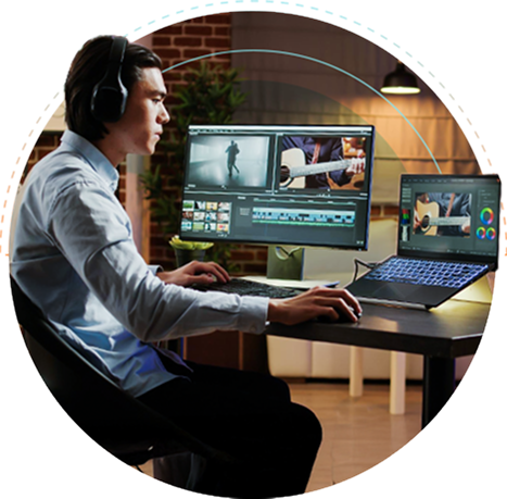 An outsourced video editor working on two laptops to edit and create multiple videos.